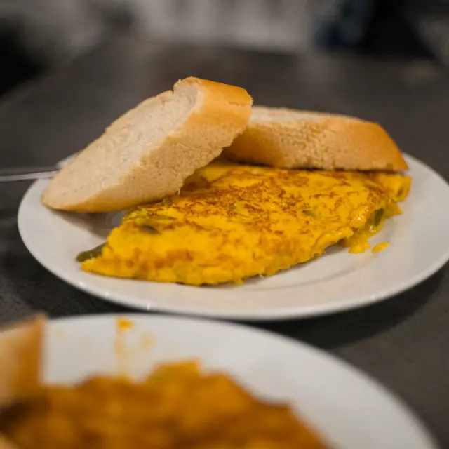 Pincho de tortilla de patatas en un plato, con dos rebanadas de pan